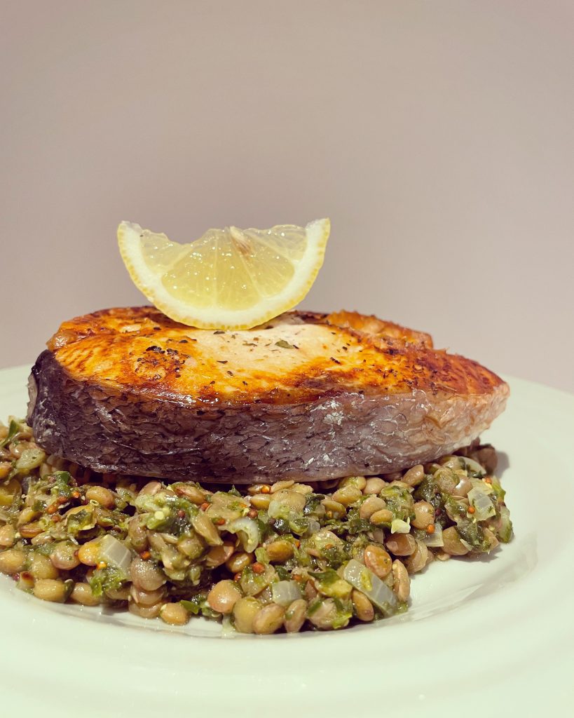 Salmon with lentils and spinach in a wholegrain mustard sauce.